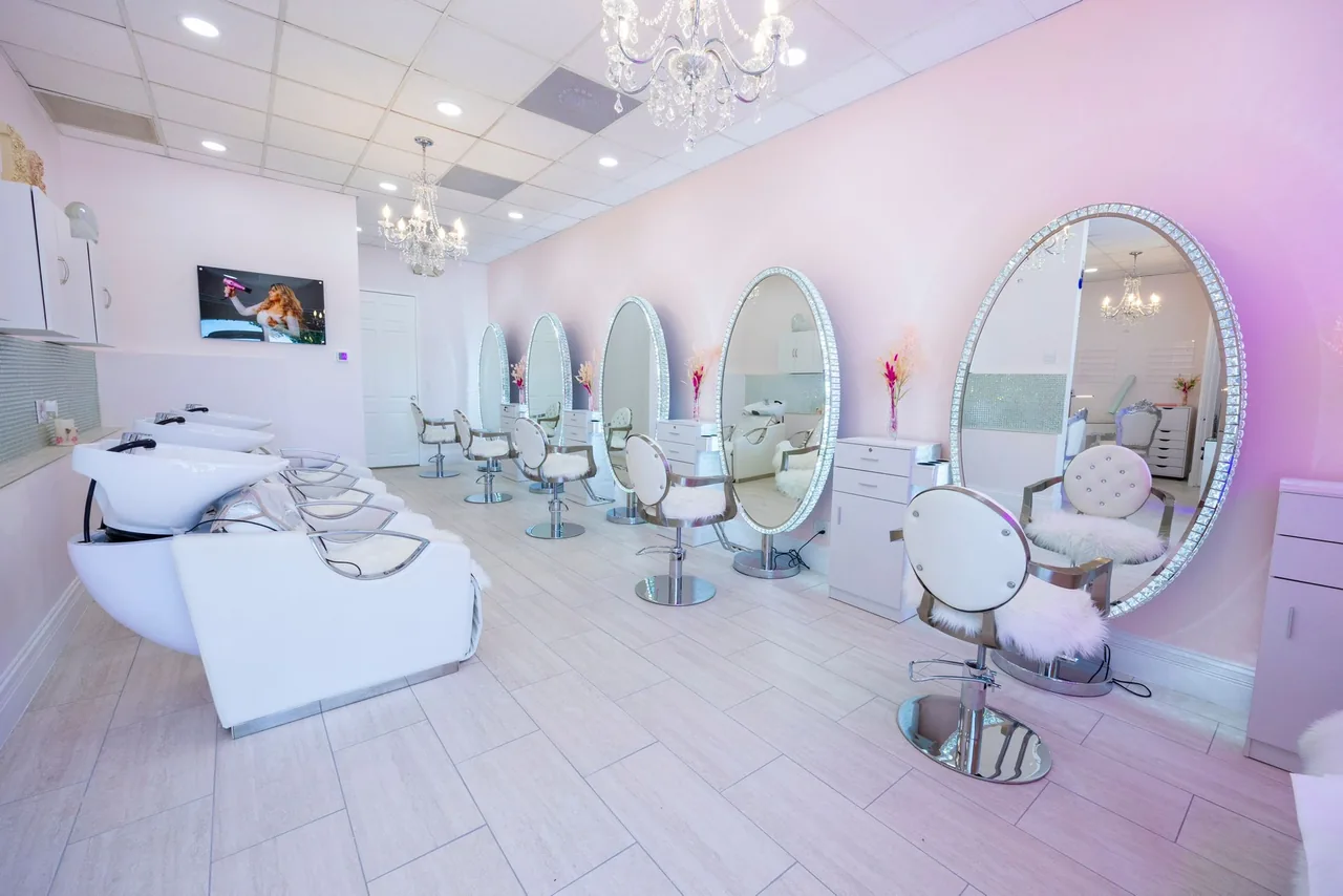 Styling stations with oval mirrors and chandeliers at The Beauties Salon on Golden Gate Pkwy